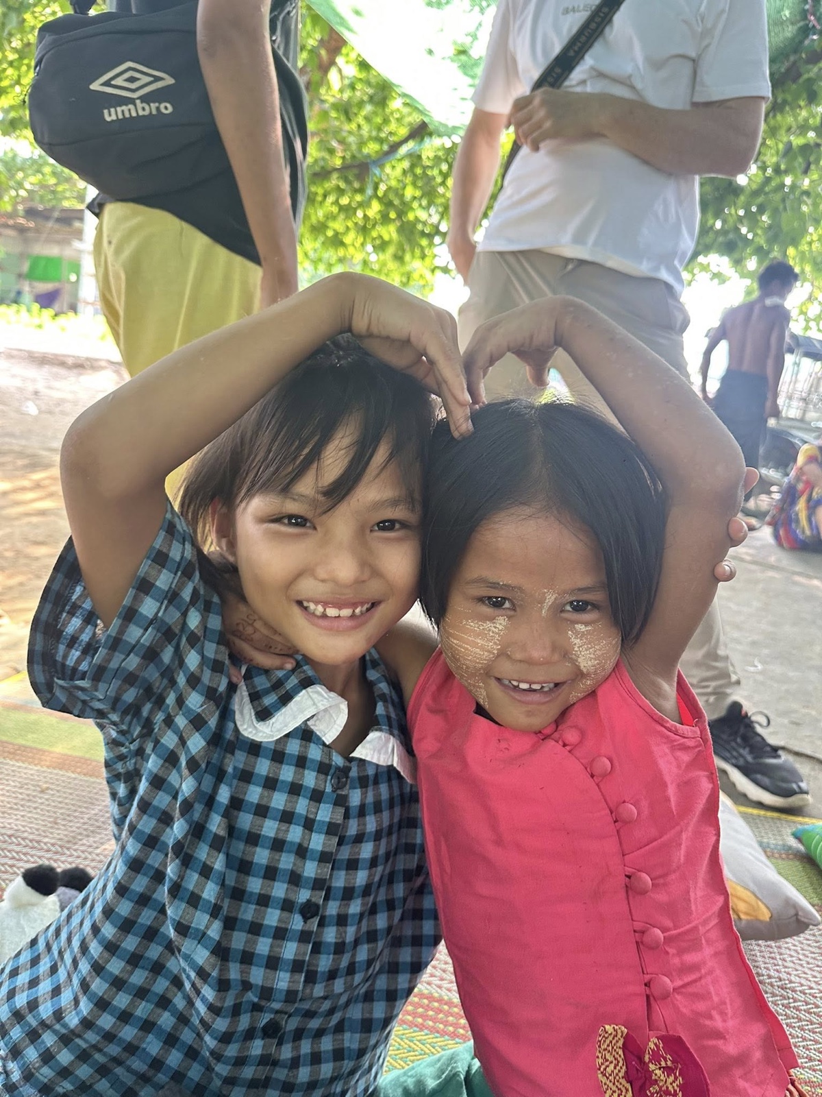 Children making heart hands at outreach
