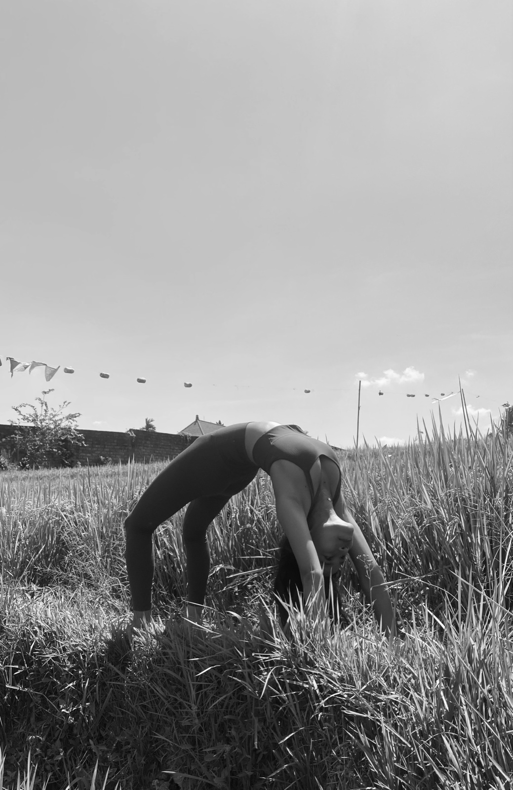 Rea practicing yoga in a rice field in Bali