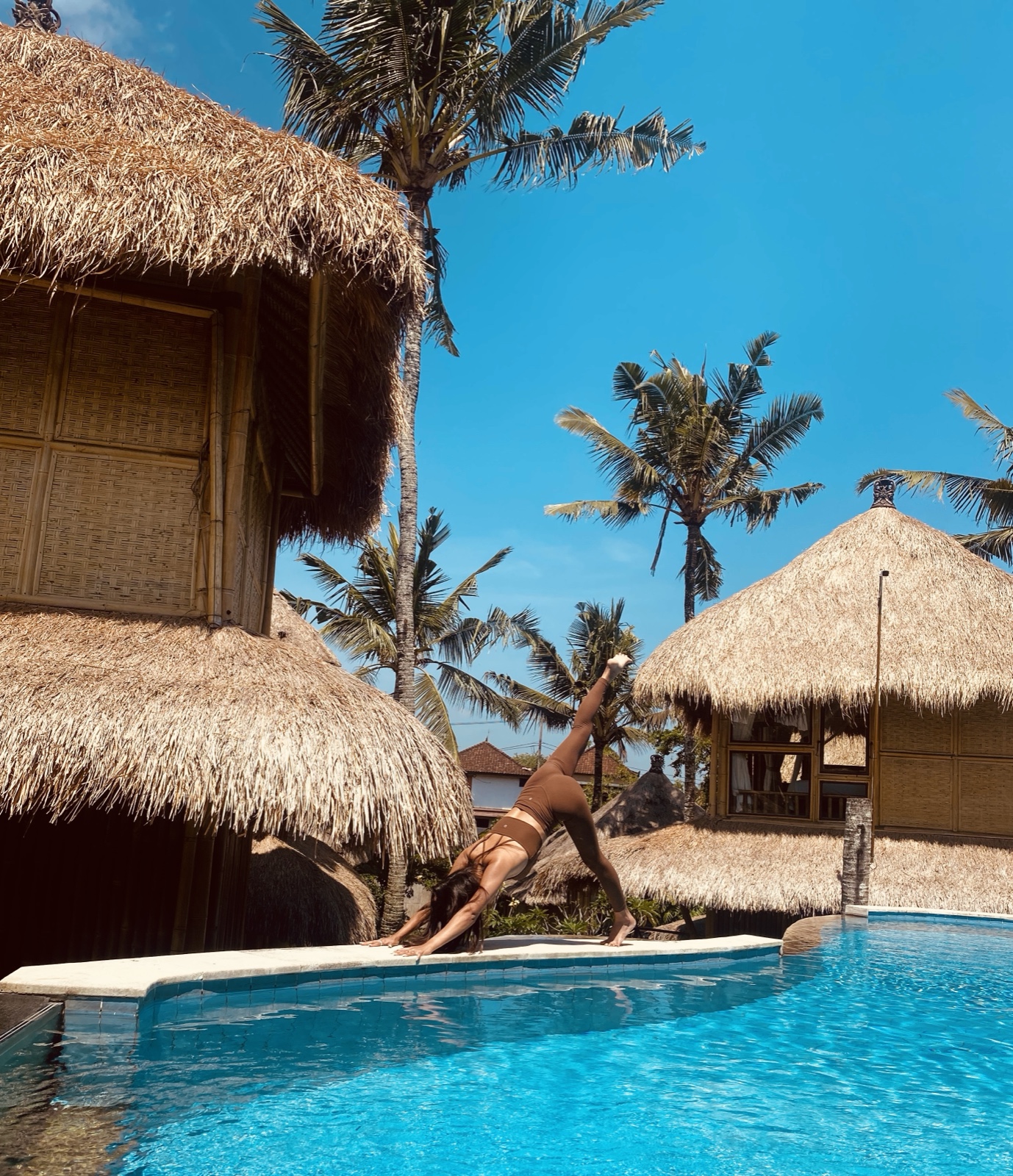Rea practicing yoga by a pool in Bali